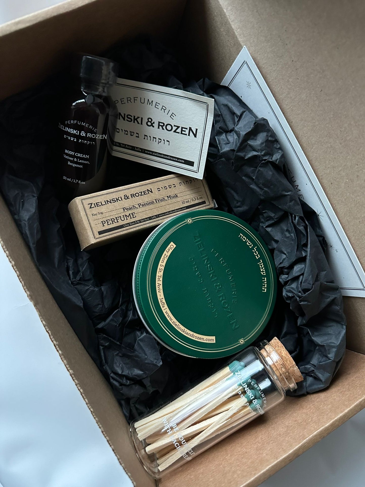 Z&R luxury gift box with perfumed candle, 10 ml perfume, body cream, and decorative matches arranged elegantly.