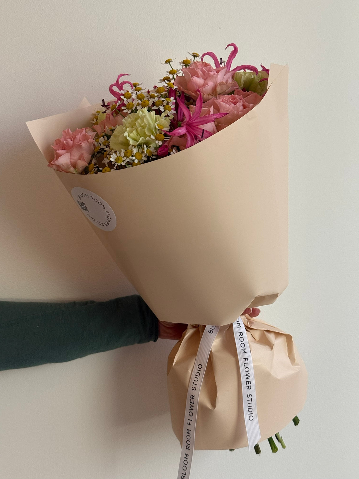 „Sweet Serenade“ floristi kimp roosade kobarrooside, roheliste nelkide, roosa nerine ja kummeliga kreemikas pakendis