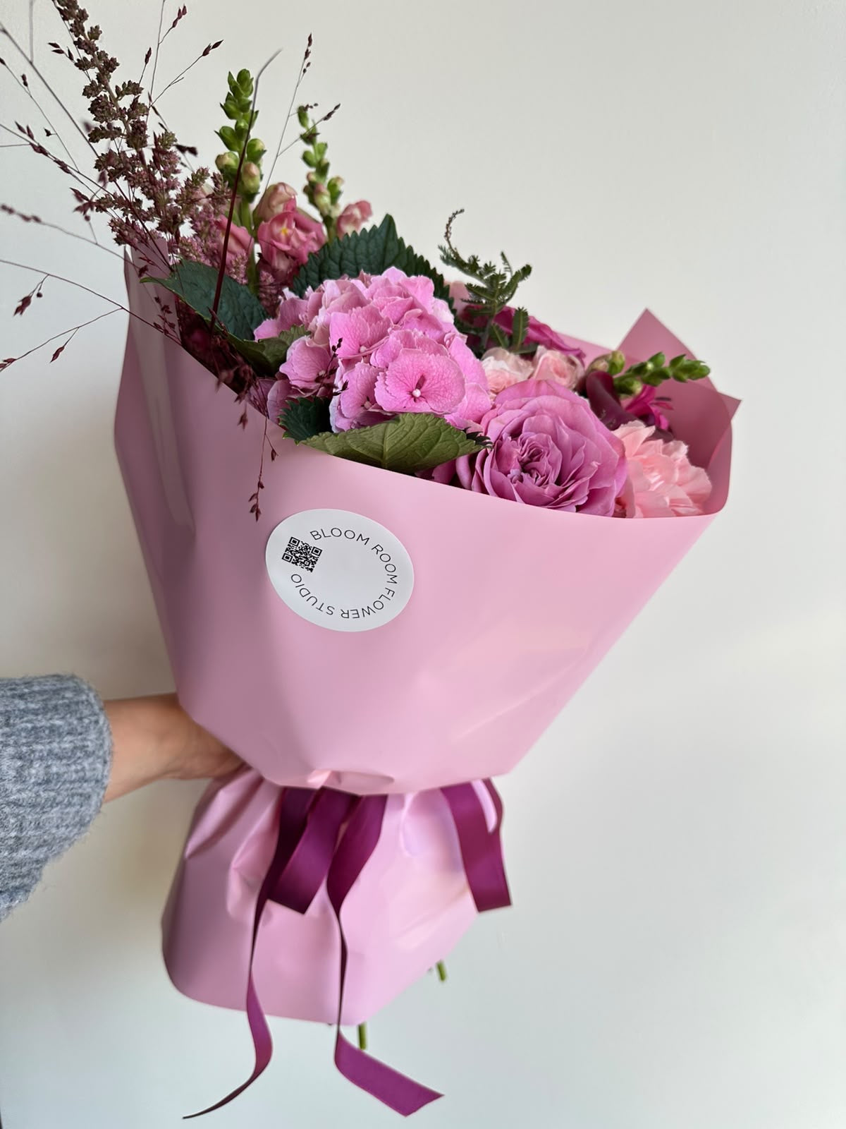 “Velvet Dream” bouquet with pink hydrangea, lilac roses, spray roses, burgundy calla and snapdragons in pink wrapping