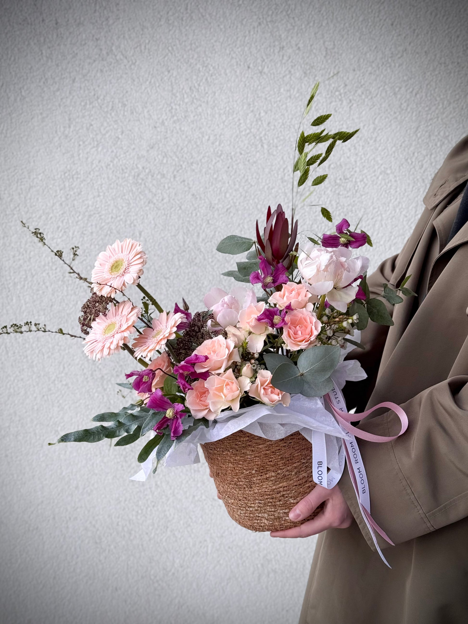 Signature flower arrangement in soft peach and blush tones, featuring spray roses, gerberas, eucalyptus, and seasonal blooms. A bubbly mix of elegance and cheer — like your favorite glass of prosecco in flower form. Comes in a natural basket with branded ribbon and care card.
