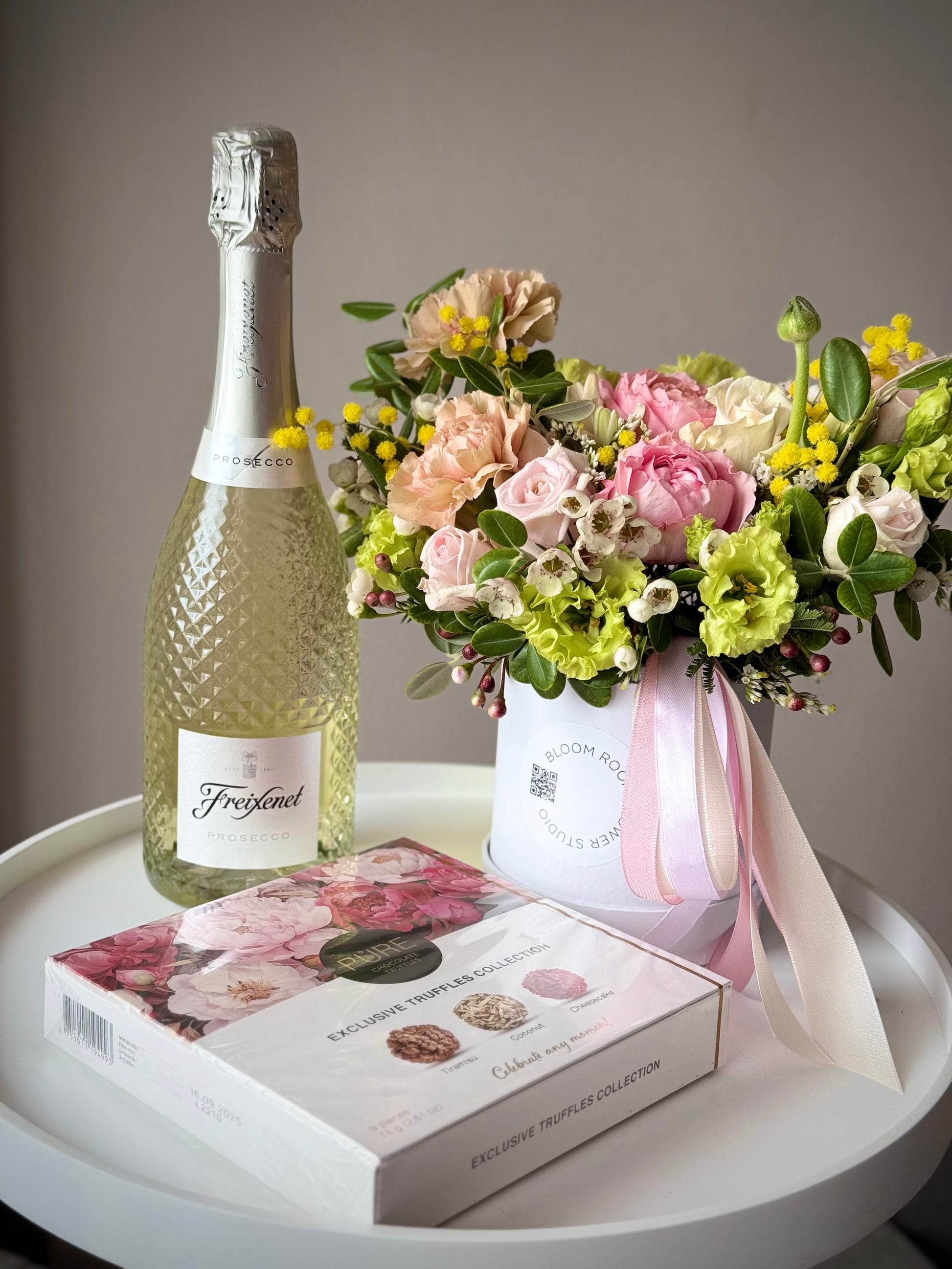 Kaunis lillekimp, Prosecco Freixenet ja maitsvad šokolaaditrühvlid valges kinkekotis | Красивый букет цветов, Prosecco Freixenet и шоколадные трюфели в белом подарочном пакете | Beautiful flower arrangement, Prosecco Freixenet, and chocolate truffles in a white gift bag