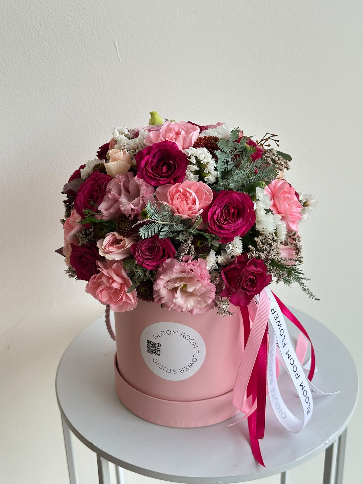 Mini Bloom Box “Blushing Heart” with cerise and pink spray roses, carnations, eustoma and limonium in a pink Bloom Room hat box