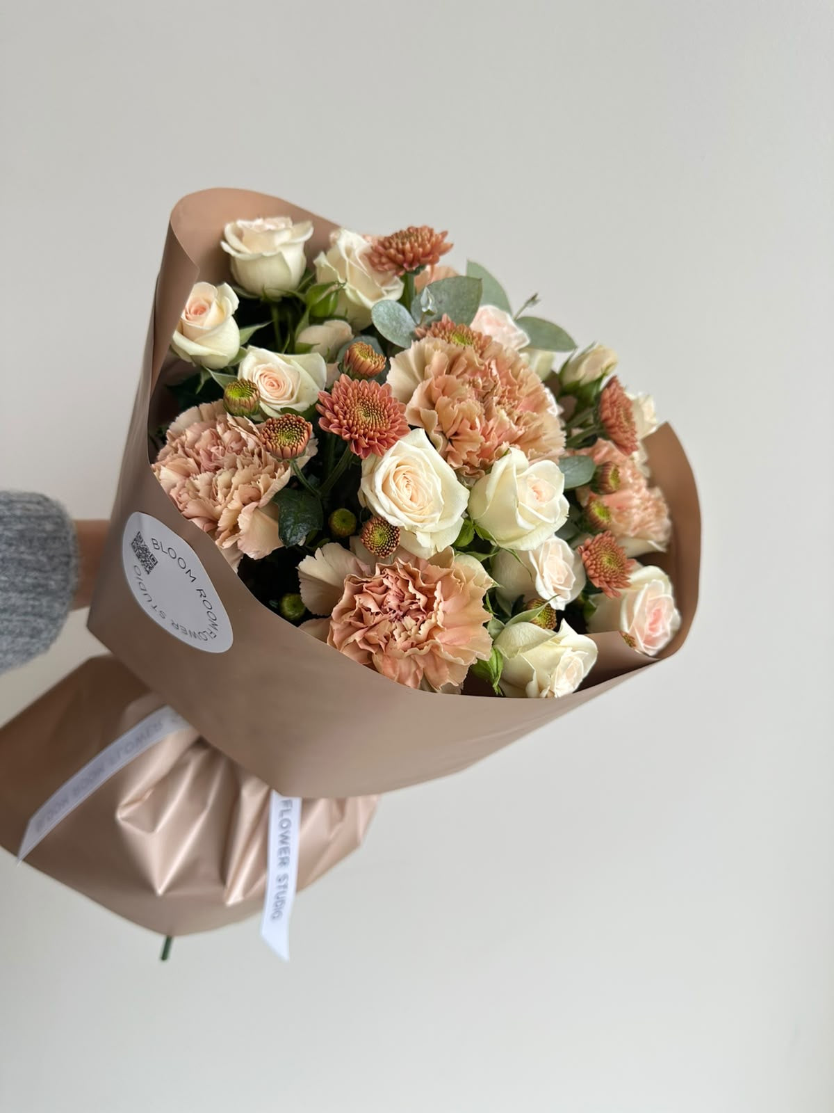 „Caramel Dream“ kimp kreemikate kobarrooside, karamellikarva nelkide, krüsanteemide ja eukalüptiga beežis pakendis