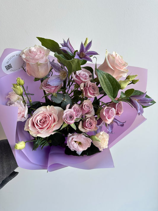 „Lavender Kiss“ floristi kimp roosade rooside, kobarrooside, preeriakella ja lilla elulõngaga lillas pakendis – BloomRoom.ee, värsked lilled Tallinnas