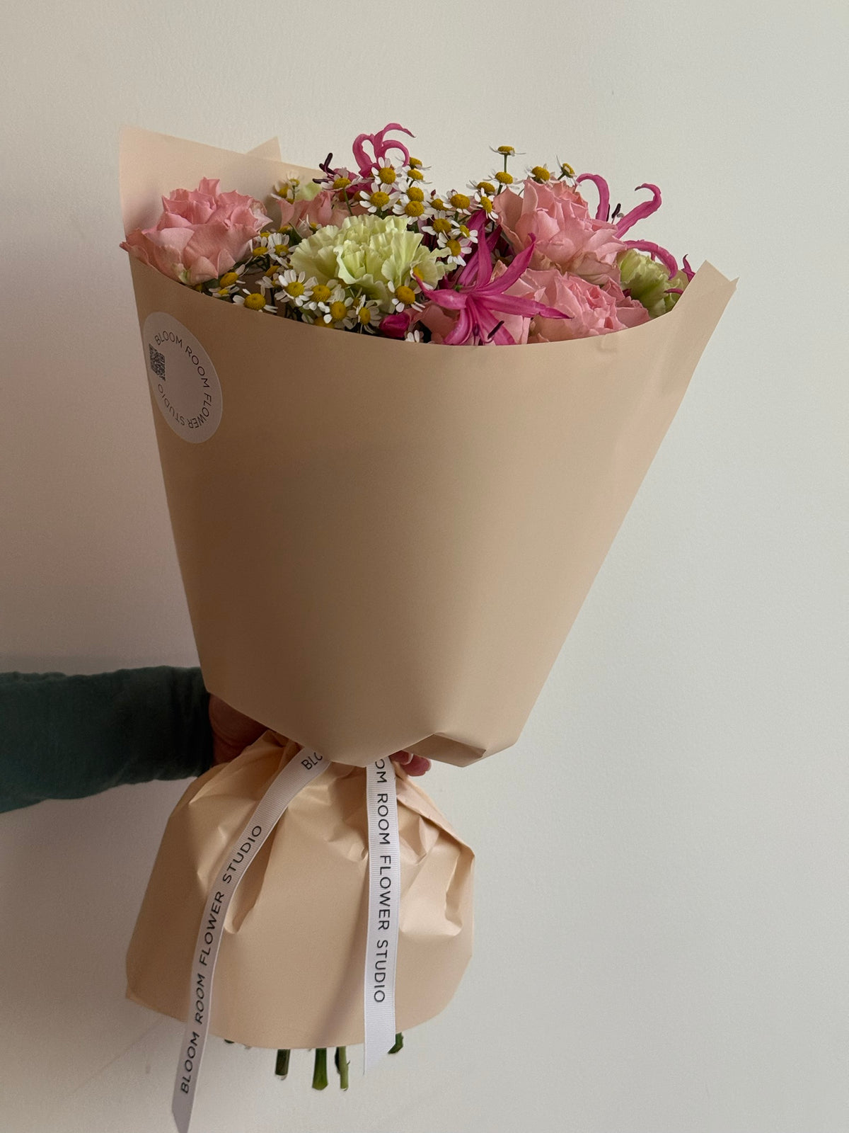 „Sweet Serenade“ floristi kimp roosade kobarrooside, roheliste nelkide, roosa nerine ja kummeliga kreemikas pakendis