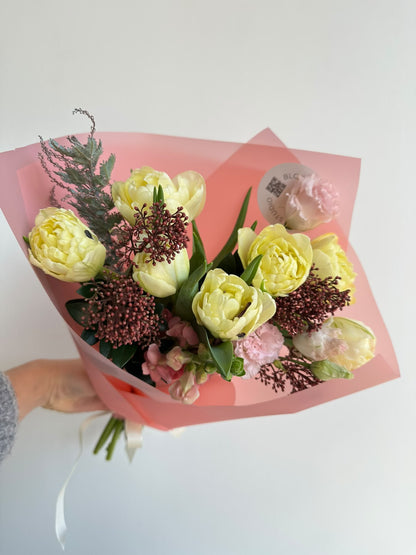 “Vanilla Romance” art bouquet with creamy peony tulips, burgundy skimmia, pink carnations and snapdragons in pink wrapping