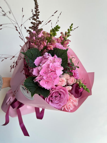 „Velvet Dream“ kimp roosa hortensia, lillakate rooside, kobarrooside, burgundia kallade ja lõvilõugadega roosas pakendis