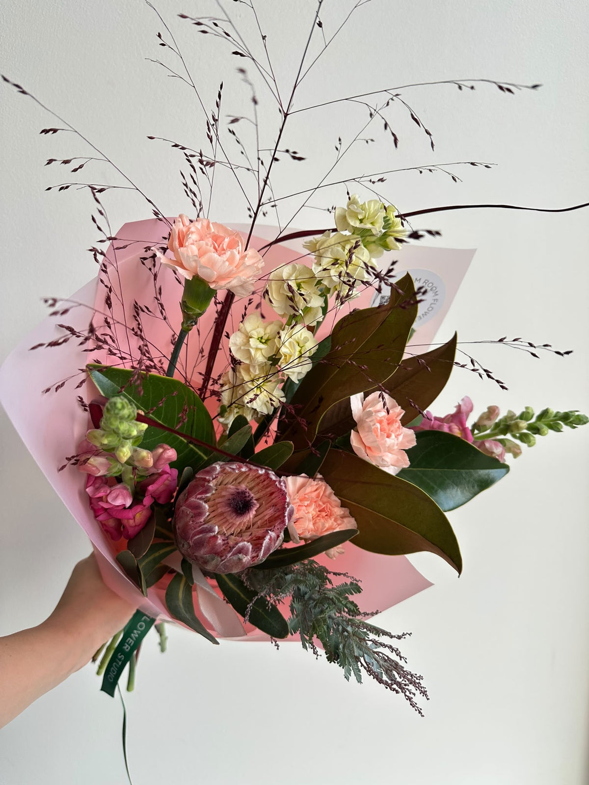 Арт-букет «Warm Autumn Dream» с розовой протеей, персиковыми гвоздиками, маттиолой и львиным зевом в розовой упаковке